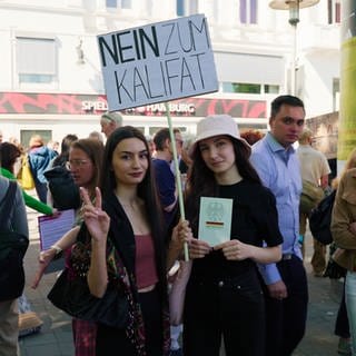 Bei einer Gegendemonstration in Hamburg gehen Menschen gegen die Forderungen nach einem Kalifat auf die Straße.