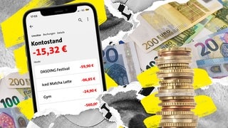 Ein Smartphone mit einer Banking-App, die einen Kontostand im Minus anzeigt. Daneben Münzen und Euroscheine.