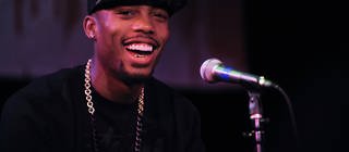 Rapper B.o.B lachend vor einem Mikrofon