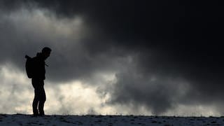Ein Mann steht vor einem dunklen Himmel (Symboldbild) Tipps: So bekommst du einen Therapieplatz