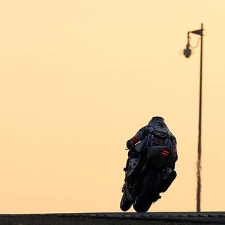SYMBOLBILD: Motorradfahrer fährt in den Horizont.