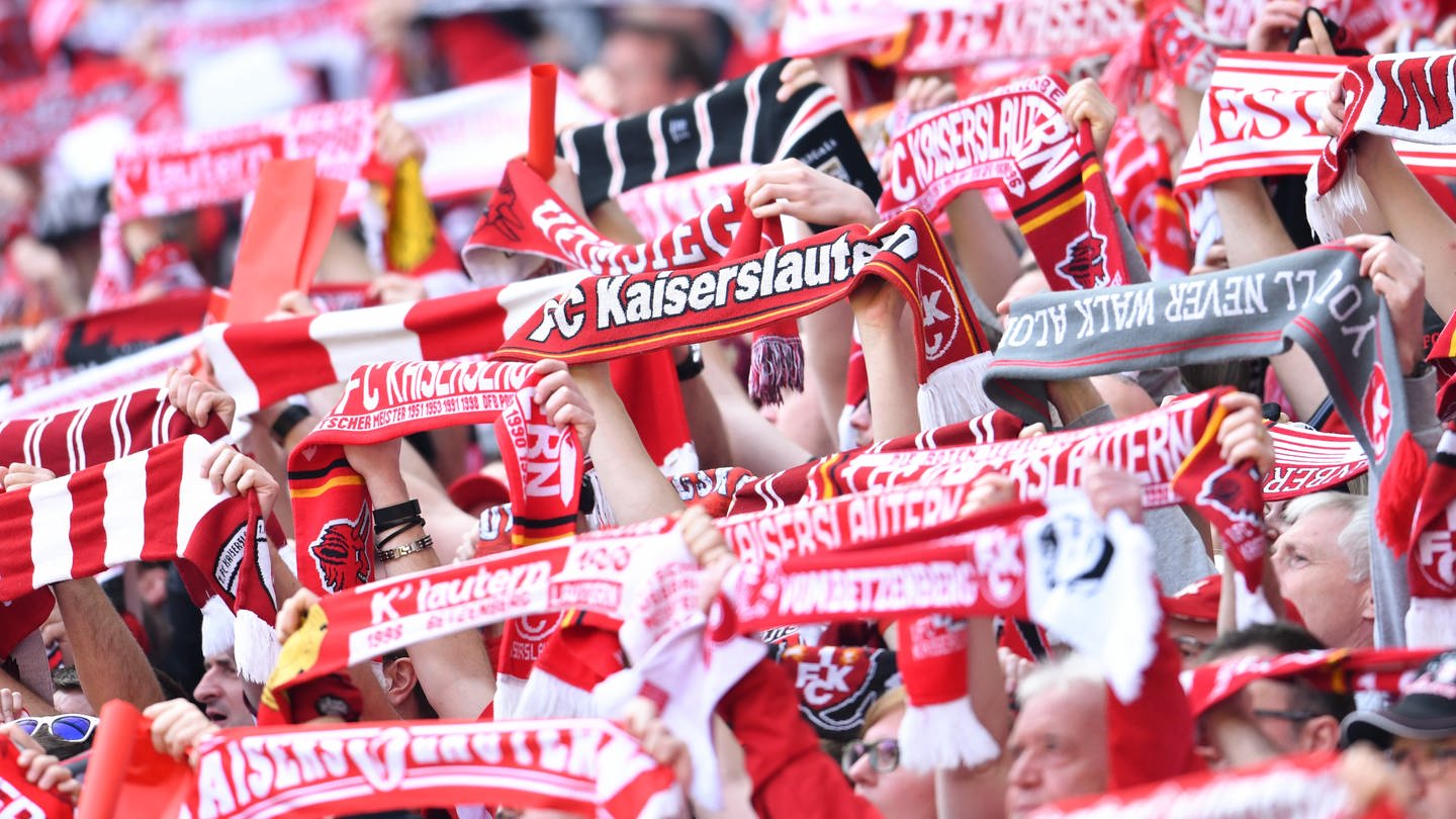 Fans des 1. FC Kaiserslautern halten vor Spielbeginn Fanschals in die Höhe.