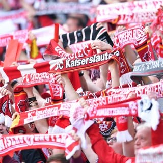  Fans des 1. FC Kaiserslautern halten vor Spielbeginn Fanschals in die Höhe. 