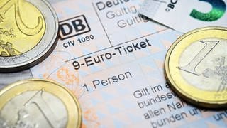 9-Euro-Ticket und Geldmünzen