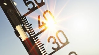 FOTOMONTAGE, Thermometer mit Sonnenstrahlen, Symbolfoto 