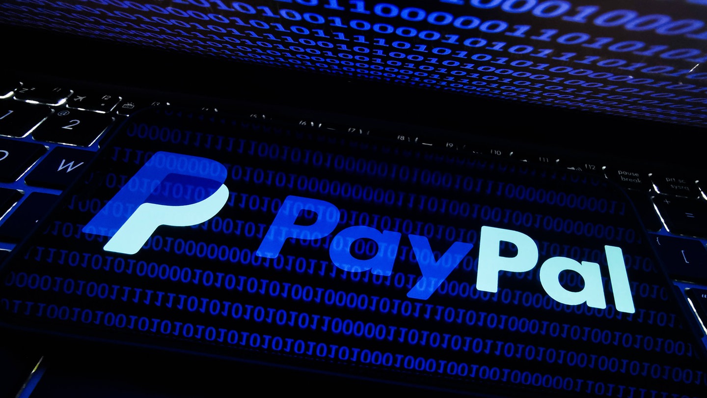 Internet Hacking Photo Illustrations PayPal logo displayed on a phone screen is seen with binary code displayed on a laptop screen in this illustration