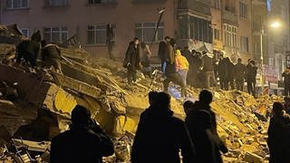 Menschen versuchen in Pazarcik in der südtürkischen Provinz Kahramanmaras, eingeschlossene Bewohner eines eingestürzten Gebäudes zu erreichen