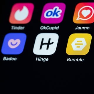 Dating Apps sind auf dem Display eines iPhone SE zu sehen. 