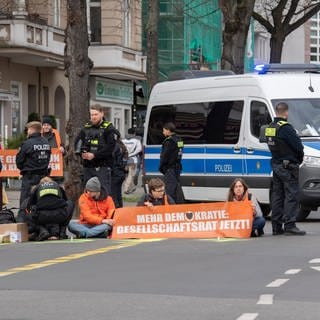 Aktivisten blockieren eine Straße in Berlin.