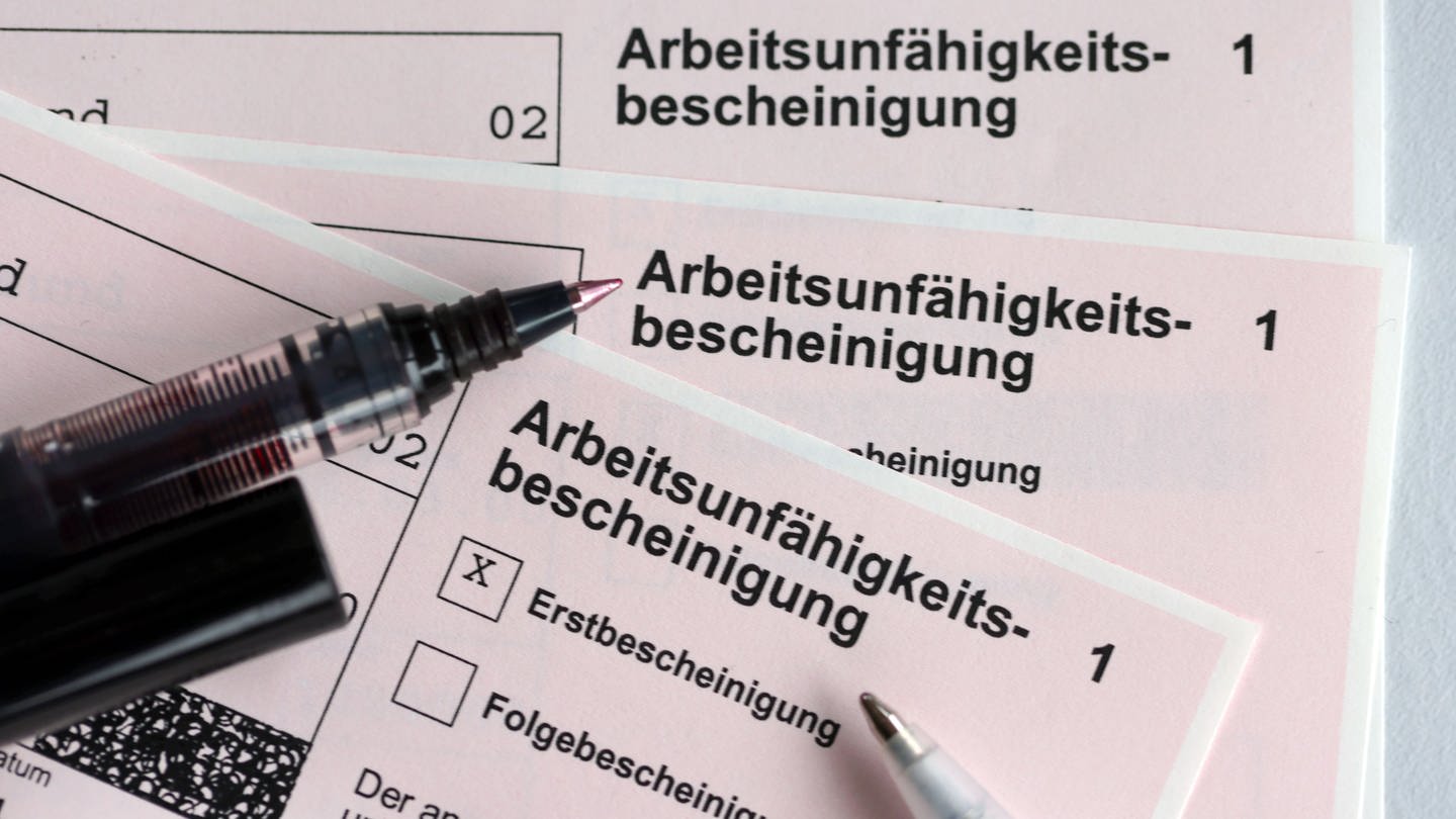 Stifte liegen auf den Arbeitsunfähigkeitsbescheinigungen für Arbeitnehmer im Falle einer Krankschreibung durch den Arzt. (zu dpa: «Krankenkasse: 2021 mehr Fehltage wegen psychischer Erkrankungen»)