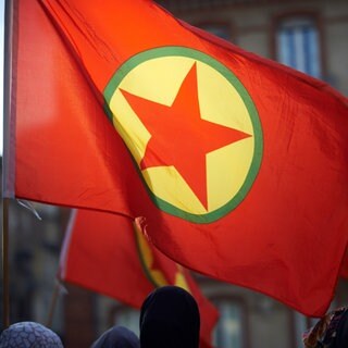 Flagge der verbotenen, kurdischen Arbeiterpartei PKK auf einer Demonstration.