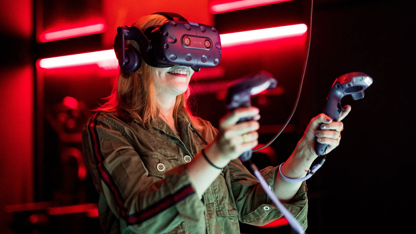 Eine Frau demonstriert eine VR-Station. 