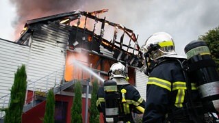 Feuerwehrleute löschen einen Brand in einer Ferienunterkunft. Elf Menschen wurden nach dem Feuer vermisst. Frankreichs Innenminister Gerald Darmanin zufolge beherbergt die Stätte behinderte Menschen.