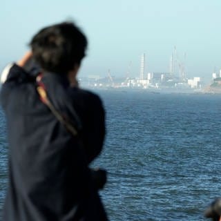 Das Kernkraftwerk Fukushima Daiichi ist vom nahegelegenen Fischereihafen Ukedo in der Stadt Namie zu sehen. Gut zwölf Jahre nach dem Super-GAU in Fukushima beginnt Japan mit der Ableitung aufbereiteten Kühlwassers aus der Atomruine ins Meer.