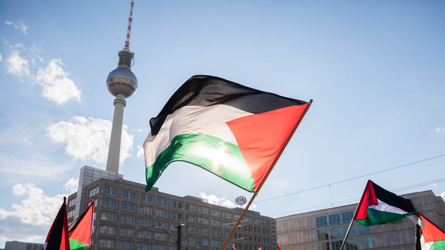 Teilnehmer einer Demonstration unter dem Motto «Gegen die israelische Aggression in Palästina» haben sich mit Fahnen auf dem Alexanderplatz versammelt.