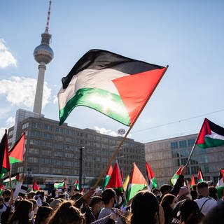 Teilnehmer einer Demonstration unter dem Motto «Gegen die israelische Aggression in Palästina» haben sich mit Fahnen auf dem Alexanderplatz versammelt.