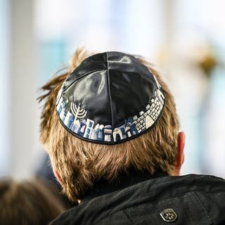 Ein Mann tägt eine Kippa bei der Kranzniederlegung auf dem jüdischen Friedhof, am Freitag den 27. Januar 2023 in Mülheim. Die Berliner Amadeu Antonio Stiftung will gemeinsam mit vielen Partnern ein Zeichen setzen: In ganz Deutschland finden vom 9. Oktober bis zum 9. November die Bildungs- und Aktionswochen "Zero Antisemitismus" statt.