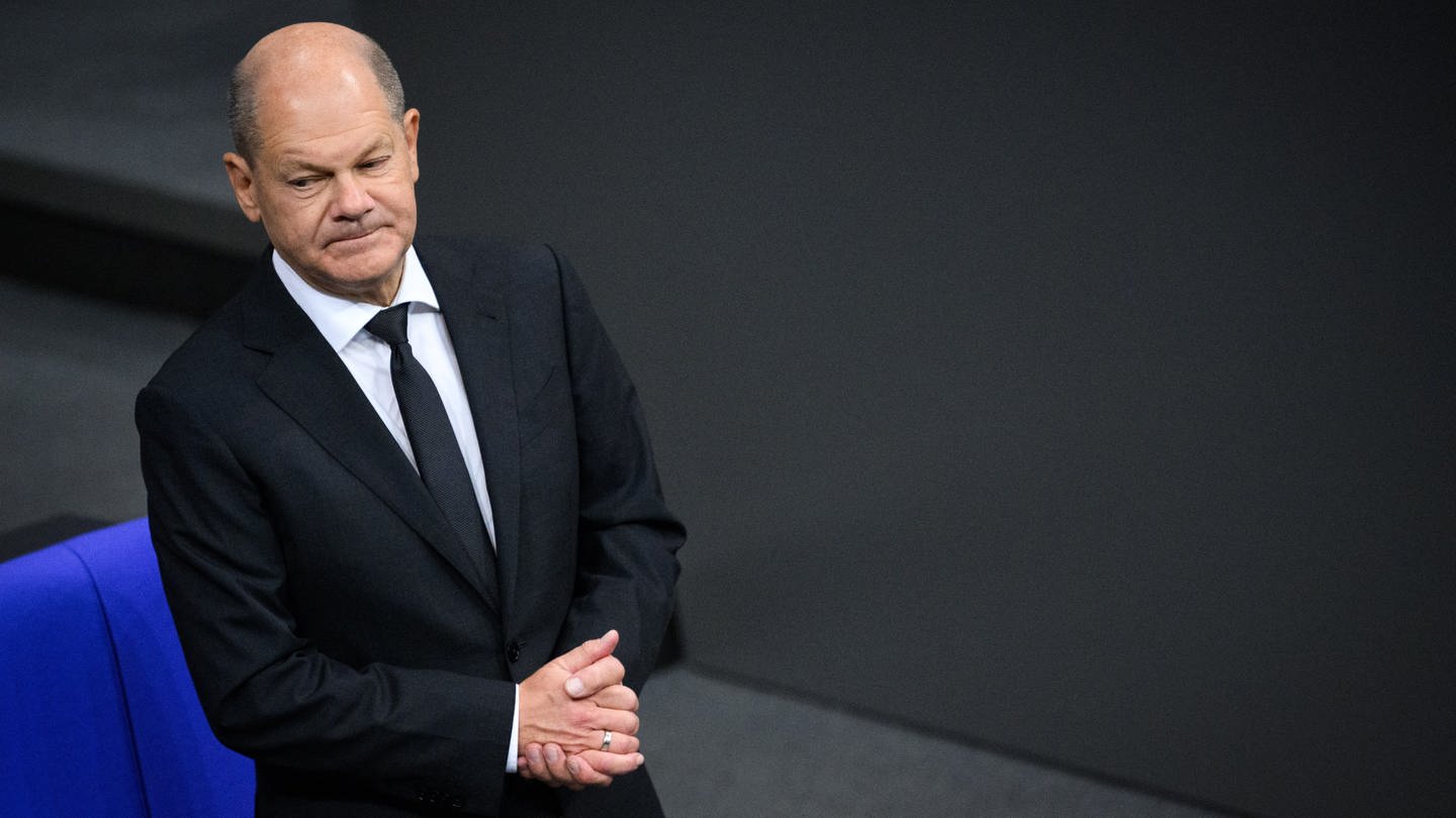 Bundeskanzler Olaf Scholz (SPD) steht zu Beginn der Plenarsitzung im Deutschen Bundestag.