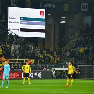 Die Spieler warten auf dem Platz die Entscheidung des Video-Schiedsrichters ab. Der DFB plant ein neues Format mit dem VAR. 