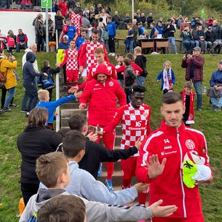 Mainz 05 Fußballer betreten das Eifelstadion in Adenau für das Benefizspiel für das Ahrtal.