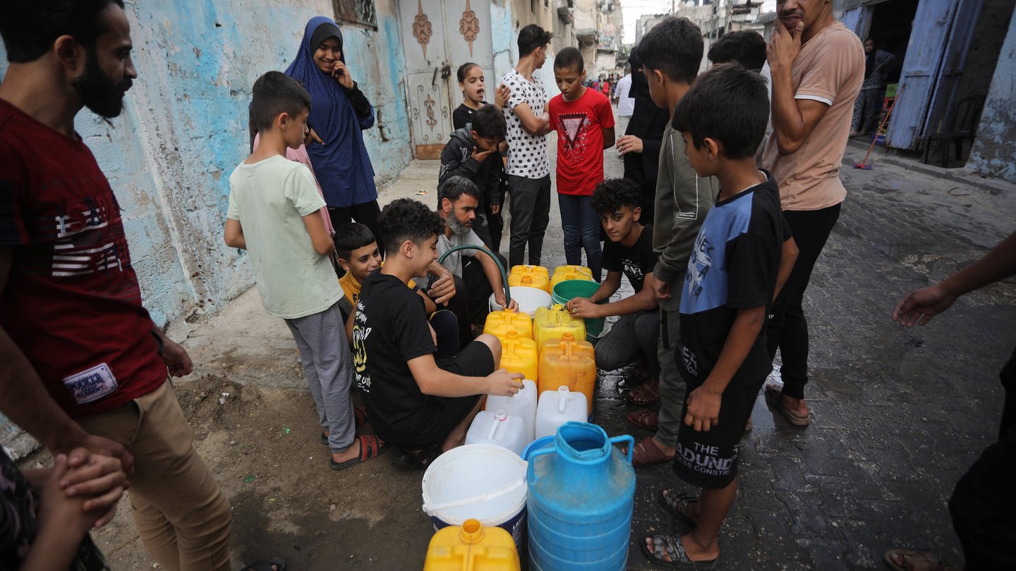 Menschen im Flüchtlingslager in Rafah (Gazastreifen) sind dabei, Wasservorräte aufzufüllen.