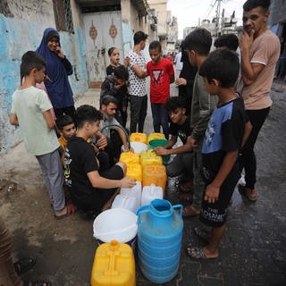 Menschen im Flüchtlingslager in Rafah (Gazastreifen) sind dabei, Wasservorräte aufzufüllen.