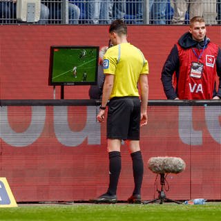 Fußball: 2. Bundesliga, Hamburger SV - Hannover 96, 27. Spieltag, Volksparkstadion. Schiedsrichter Florian Badstuber schaut sich nach dem Anruf des VAR eine Spielszene auf dem Bildschirm an. 