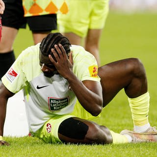 Ragnar Ache vom 1. FC Kaiserslautern liegt am Boden, nachdem er von einer Flasche getroffen wurde