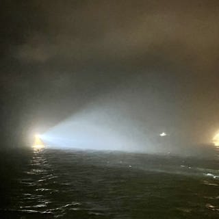 Das via PA zur Verfügung gestellte Handout zeigt Suchscheinwerfer, die das Wasser in der Nähe der Stelle absuchen, an der das britische Frachtschiff «Verity» nach einer Kollision mit dem Schiff «Polesie» in der Nordsee nahe der deutschen Insel Helgoland gesunken sein soll.