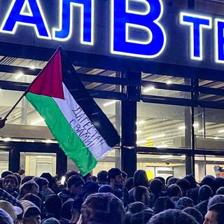 Ein wütender Mob vor dem Flughafen in Machatschkala, Dagestan. Eine Palestina-Flagge mit der Aufschrift "Dagestan steht hinter euch" wird geschwenkt.