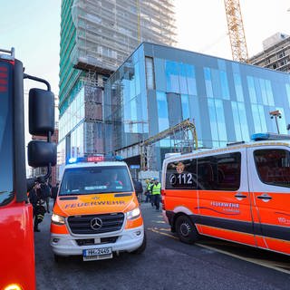 Einsatzfahrzeuge der Feuerwehr stehen vor einem eingerüsteten Hochhaus. Auf einer Baustelle in der Hamburger HafenCity sind am Montag mehrere Arbeiter von einem Gerüst gestürzt.