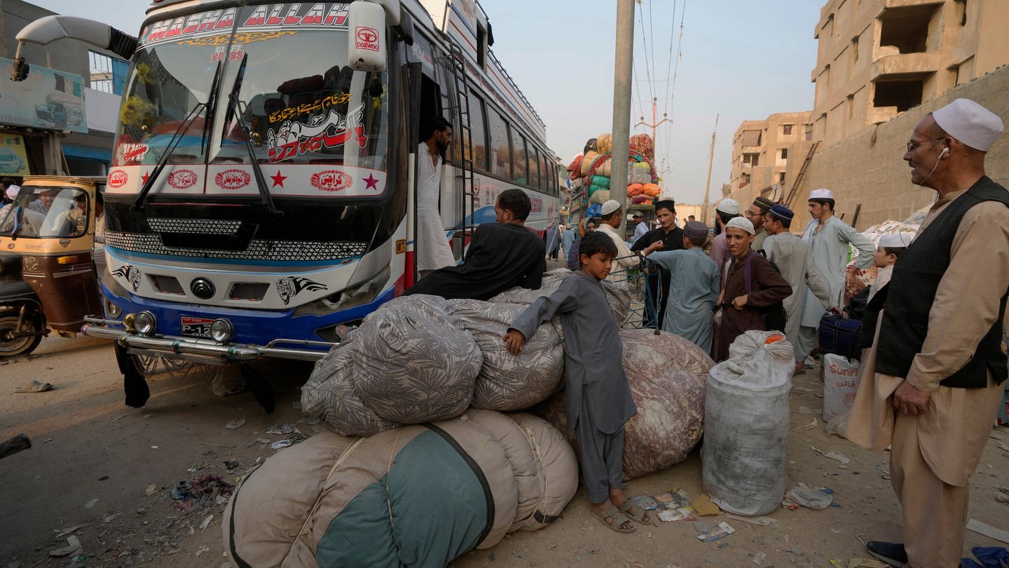 Afghanische Familien warten darauf, in Busse einzusteigen, die sie in ihr Heimatland bringen sollen. UN-Organisationen berichten von einem starken Anstieg der Zahl der Afghanen, die in ihre Heimat zurückkehren, seit Pakistan ein hartes Durchgreifen gegen illegal im Land lebende Menschen eingeleitet hat.