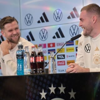 Die Nationalspieler Niclas Füllkrug und Marvin Ducksch bei einer Pressekonferenz des DFB. In einem Stream sagten sie, dass sie bei "7 vs. Wild" mitmachen würden.