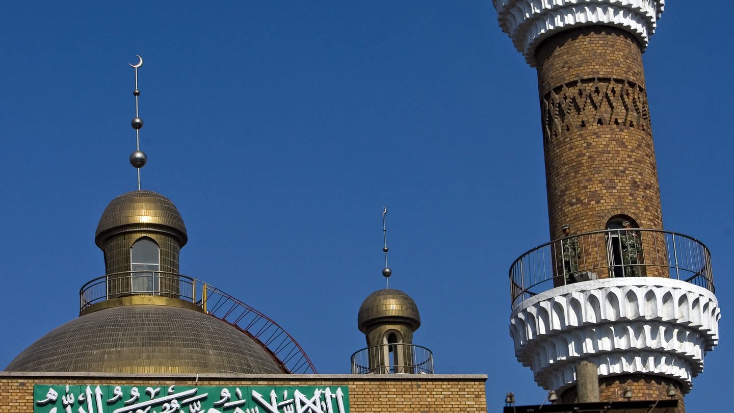 Security forces (R) stand guard atop a tower of a mosque hours before Firday prayer in Urumqi, Xinjiang province, China, 10 July 2009.