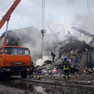 Rettungskräfte arbeiten an einem durch Beschuss beschädigten Gebäude. Forscher haben errechnet, dass durch den Ukraine-Krieg richtig viel CO2 entsteht.