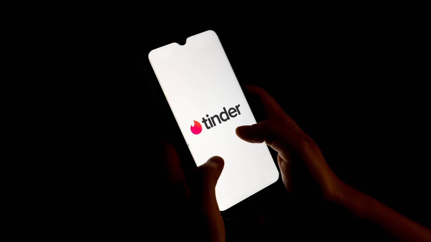 Das Tinder-Logo ist auf einem Smartphone zu sehen.