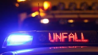 Ein Blaulicht und der Schriftzug "Unfall" leuchtet auf einem Polizeiwagen.