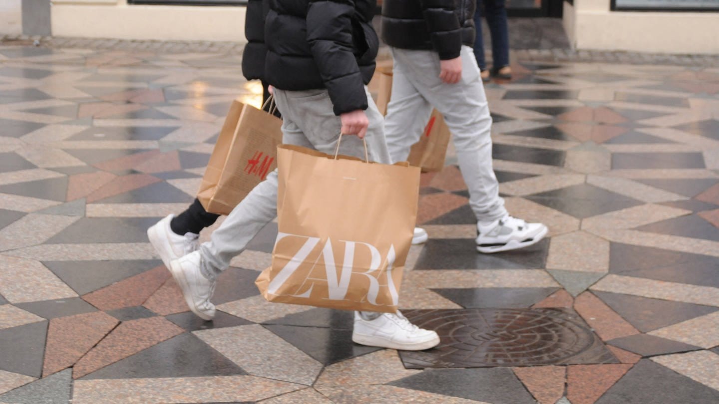 Zwei Jugendliche mit Einkaufstaschen von Zara und H&M: Bei Zara gibt es online bald Secondhand-Mode zu kaufen