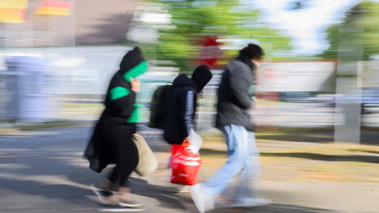 Drei Geflüchtete gehen zu einer Landesaufnahmebehörde in Deutschland. In Baden-Württemberg gibt es ein Streetwork-Projekt für junge Männer.