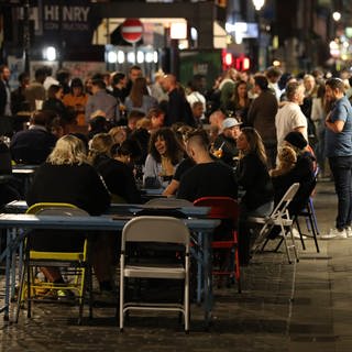 Eine Gruppe Jugendlicher sitzt draußen im Pub