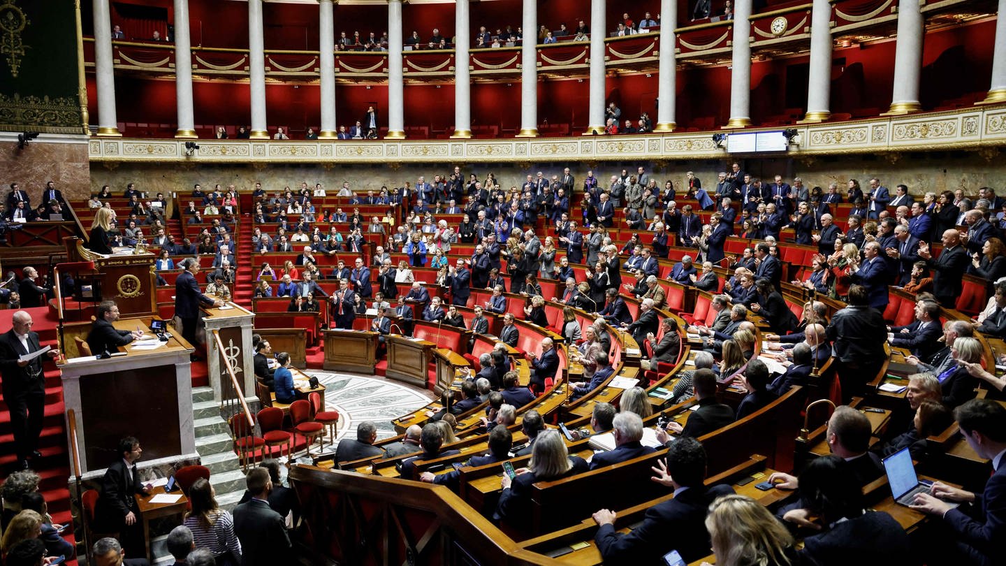 Gerald Darmanin, Innenminister von Frankreich, spricht zu Beginn einer Debatte in der französischen Nationalversammlung über den Gesetzesentwurf zu einem Immigrationsgesetz in verschärfter Fassung, während die Abgeordneten der Renaissance stehen und applaudieren.