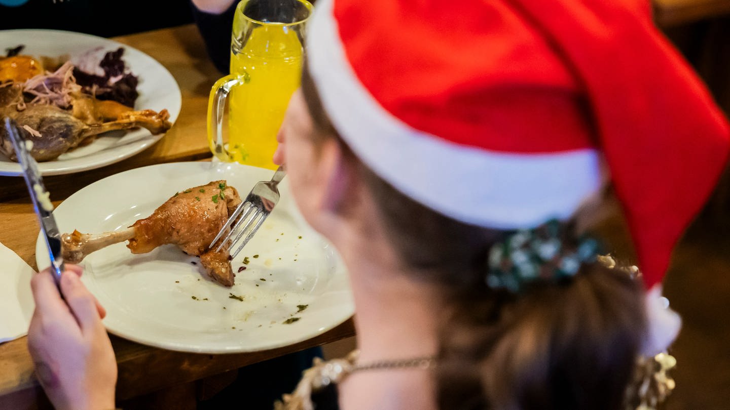 Ein Mädchen isst bei einem kostenlosen Weihnachtessen der Arche und des Hofbräus Berlin für Kinder und Familien aus benachteiligten Verhältnissen im Hofbräu Wirtshaus.