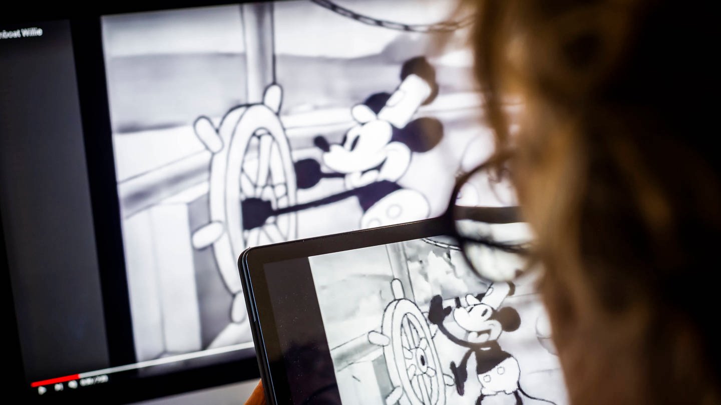 Steamboat Willie: Copyright-Ende. Eine Frau schaut sich am Dienstag, den 2. Januar 2024, in New York den Zeichentrickfilm Steamboat Willie von Walt Disney Co.™ an. 