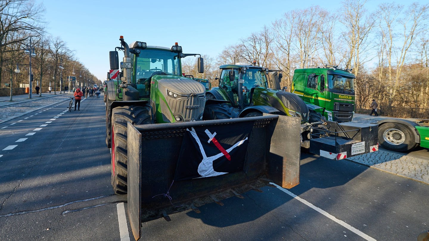 Bei den Bauern-Protesten in Berlin fahren Trecker mit Landvolkbewegungsflaggen