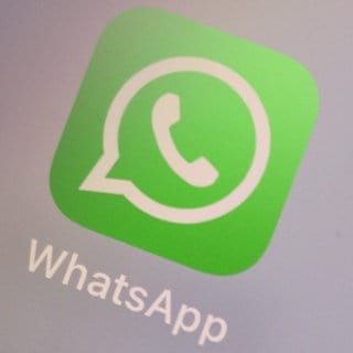 Auf einem iPhone Display wird ein WhatsApp-Logo angezeigt. Es soll bald ein neues Update für WhatsApp geben.