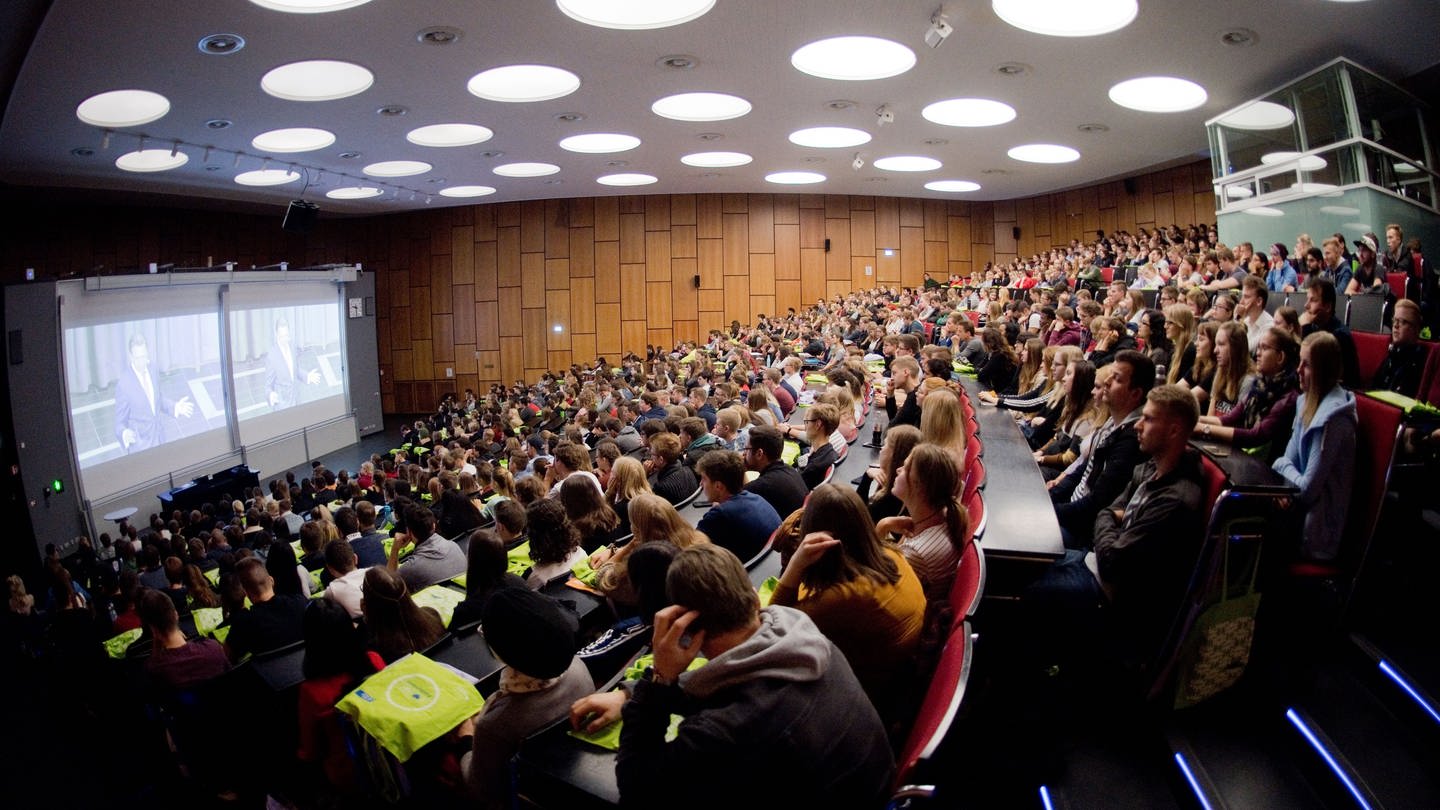 Studenten sitzen bei der Erstsemesterbegrüßung im Audimax in der Leibniz Universität.