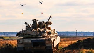 Soldaten der von der Nato verstärkten «Forward Presence Battle Group Poland», die operativ von der 1st Infantry Division (1 ID) geführt werden, beobachten zwei polnische Hubschrauber, die während einer Bull Run-Übung, über sie hinwegfliegen.