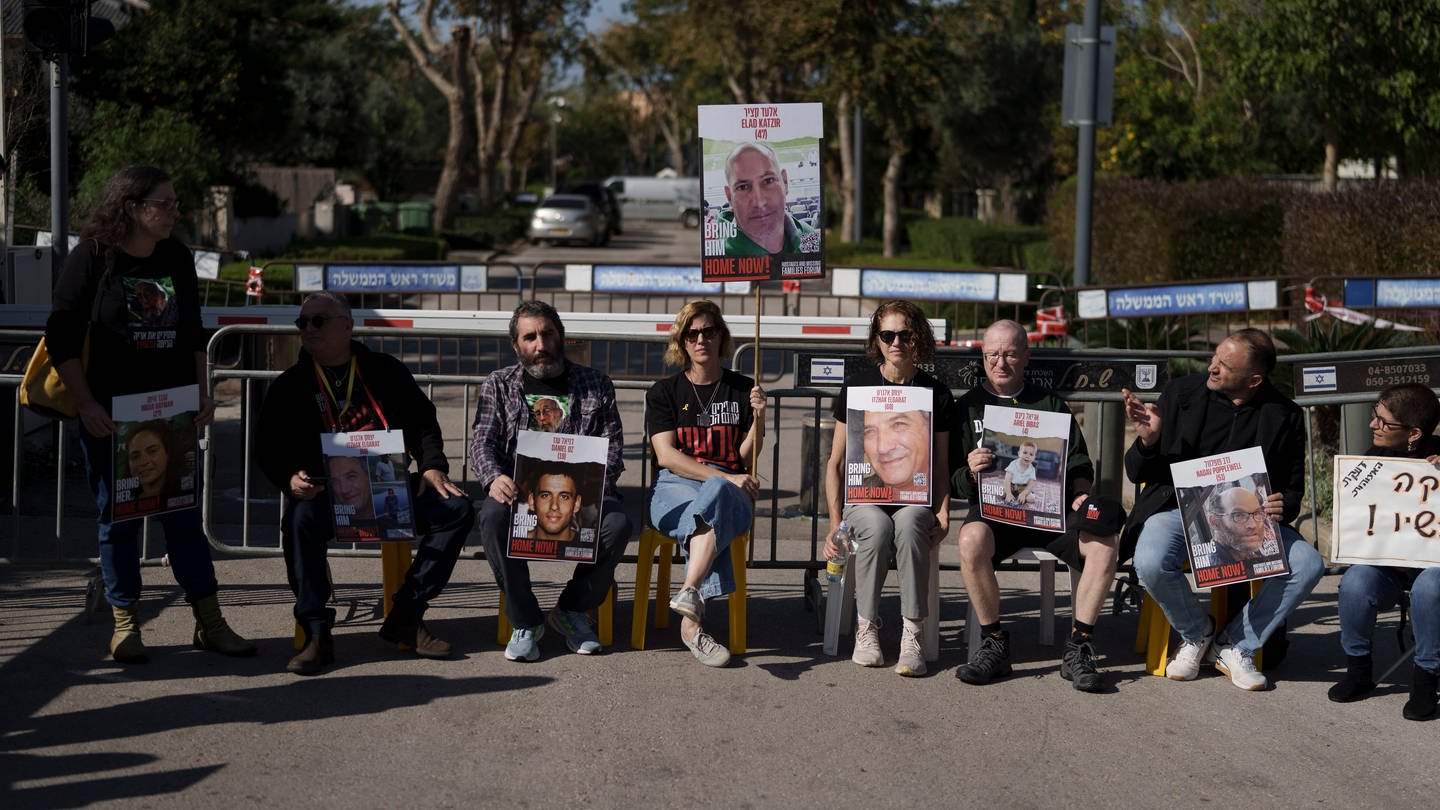 Angehörige und Freunde von Geiseln sitzen auf einer Straße vor dem Privathaus des israelischen Ministerpräsidenten Netanjahu in Caesarea. Erneut protestierten Hunderte Menschen gegen die Regierung von Ministerpräsident Netanjahu.