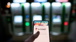 Ein Mann hält ein Mobiltelefon, auf dem das «D-Ticket» gekauft werden kann. Das Deutschlandticket soll auch im Jahr 2024 49 Euro im Monat kosten.