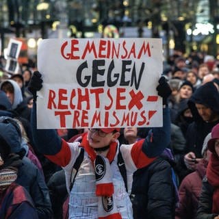 Ein Teilnehmer der Demonstration "Hamburg steht auf" gegen die AFD und Rechtsextremisms hält ein Plakat mit der Aufschrift "Gemeinsam gegen Rechtsextremismus".